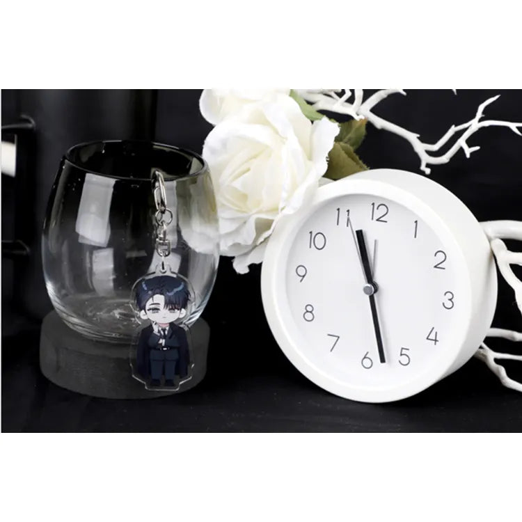 Debut Or Die VTIC Cheongryeo Acrylic Keychain hanging on a glass cup next to a white clock and white flowers